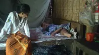 Tasripah (80) memandangi tubuh kurus Karmijan (52), anaknya semata wayang yang sakit menahun. (foto : Liputan6.com/felek/edhie prayitno ige)