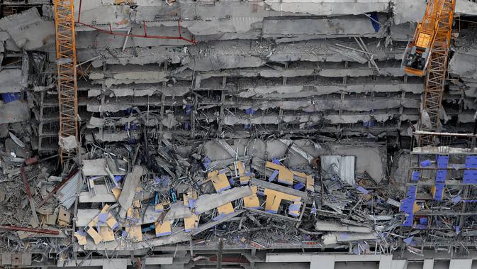 Gambar udara memperlihatkan bangunan Hard Rock Hotel yang tengah dibangun runtuh di pusat kota New Orleans, Sabtu (12/10/2019). Media lokal setempat mengatakan, 3 orang lainnya hilang dan anjing penyelamat dikerahkan untuk mencari korban. (AP Photo/Gerald Herbert)
