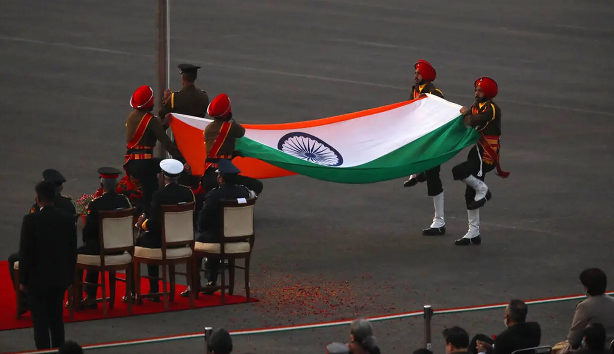 Tentara India melipat bendera nasional saat matahari terbenam selama upacara Beating Retreat di Raisina Hills, pusat kekuasaan pemerintah, New Delhi, India, Jumat (29/1/2021). Upacara tersebut menandai akhir dari perayaan Hari Republik tahunan. (AP Photo/Manish Swarup)
