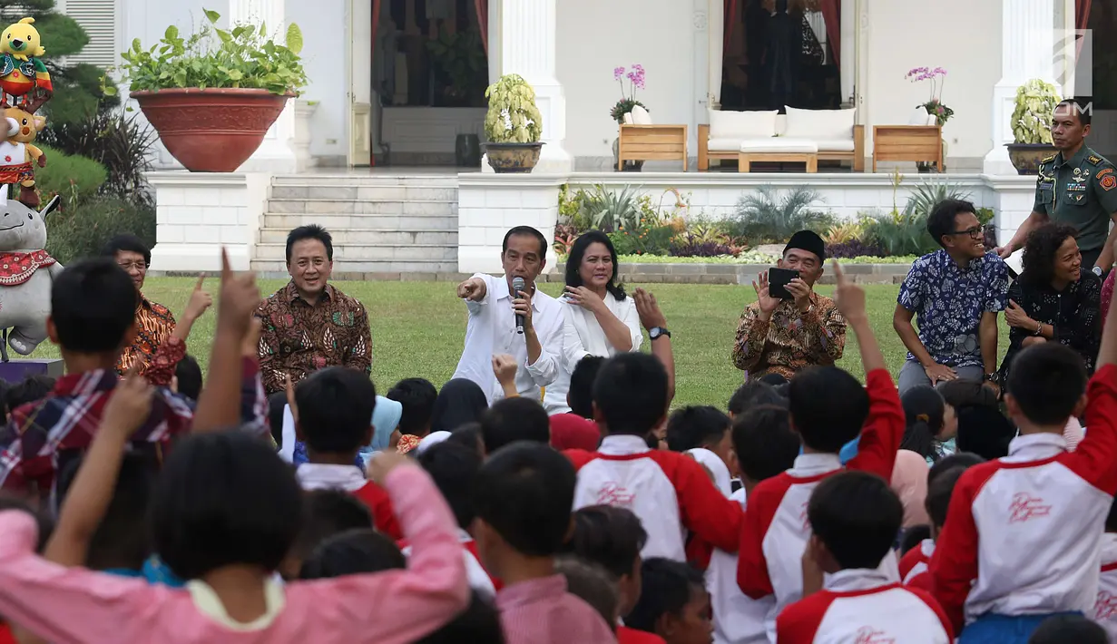 Presiden Joko Widodo dan Ibu Negara Iriana menunjuk seorang anak pada acara bermain, berdendang dan berimajinasi bersama anak-anak dari beberapa sekolah di halaman belakang Istana Merdeka, Jakarta, Jumat (20/7). (Liputan6.com/Angga Yuniar)