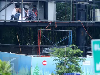 Tiga pekerja sedang melakukan perbaikan papan reklame di Kawasan Senayan, Jakarta, Kamis, (6/10). Papan reklame diremajakan agar tidak roboh diterpa hujan deras disertai angin kencang. (Liputan6.com/Gempur M. Surya)