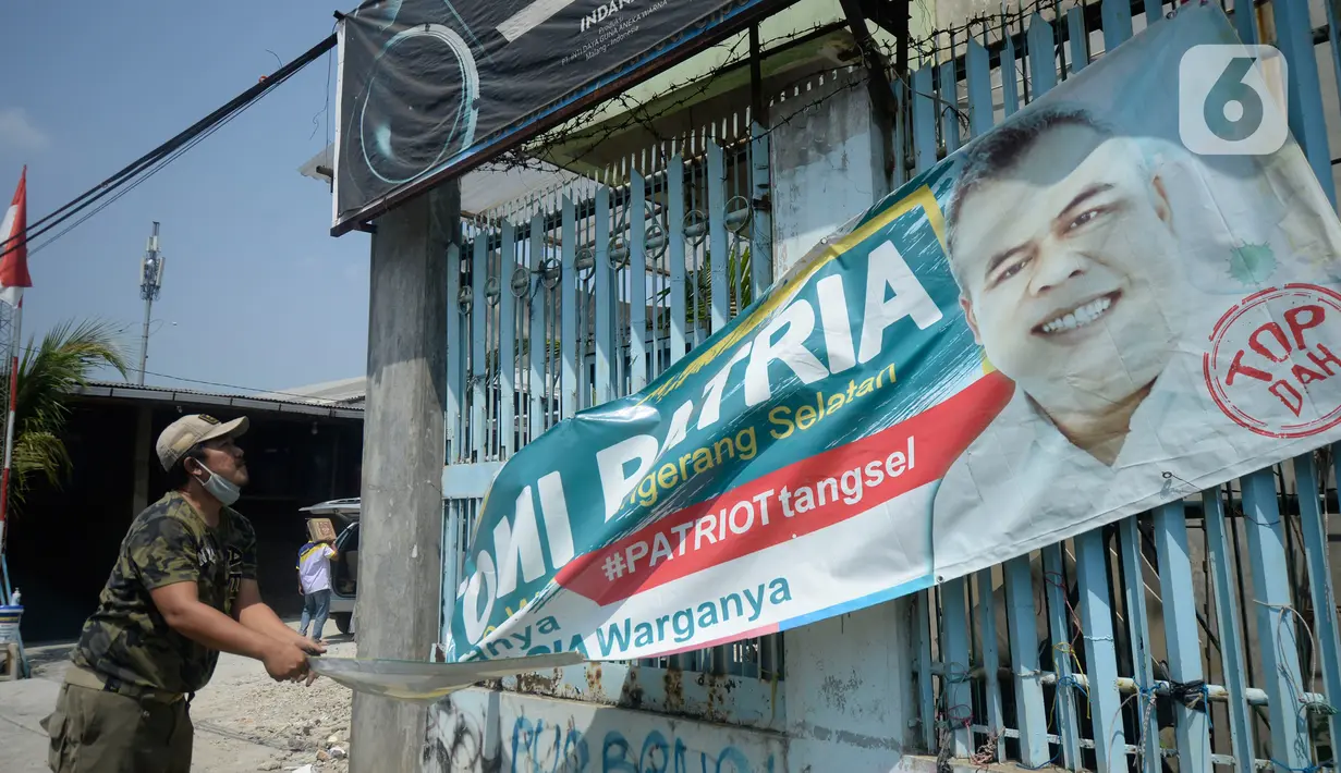 Petugas Satpol PP menertibkan Alat Peraga Kampanye (APK) bakal calon Wali Kota dan Wakil Wali Kota Tangerang Selatan di sepanjang jalan raya di Kota Tangerang Selatan, Kamis (27/8/2020). Semua poster dan baliho diturunkan karena tidak memiliki izin dan masa izin telah habis. (merdeka.com/Dwi Narwoko