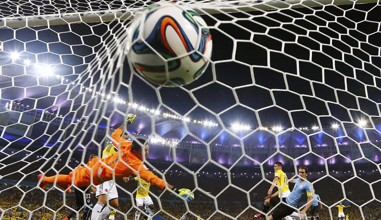 Penjaga gawang Timnas Uruguay, Fernando Muslera, tidak mampu membendung tendangan pemian depan Kolombia, James Rodriguez di laga 16 besar Piala Dunia 2014 di Stadion Maracana, Rio de Janeiro, (29/6/2014). (REUTERS/Michael Dalder)