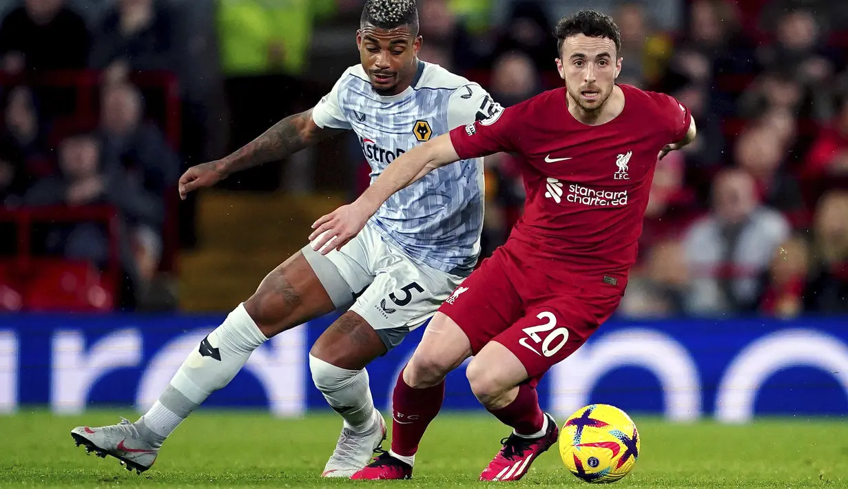 Pemain Liverpool, Diogo Jota (kanan) berebut bola dengan pemain Wolverhampton, Mario Lemina pada laga lanjutan Liga Inggris 2022/2023 yang berlangsung di Anfield, Liverpool, Kamis (02/03/2023) WIB. Liverpool menang dengan skor 2-0. (AP Photo/PA/Peter Byrne)