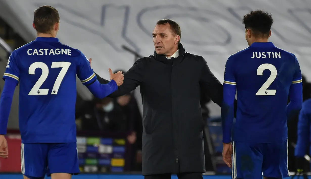 Manajer tim Leicester City, Brendan Rodgers (tengah) menyalami bek Timothy Castagne (kiri) usai berakhirnya laga lanjutan Liga Inggris 2020/21 pekan ke-19 melawan Chelsea di King Power Stadium, Leicester, Selasa (19/1/2021). Leicester City menang 2-0 atas Chelsea. (AFP/Rui Vieira/Pool)