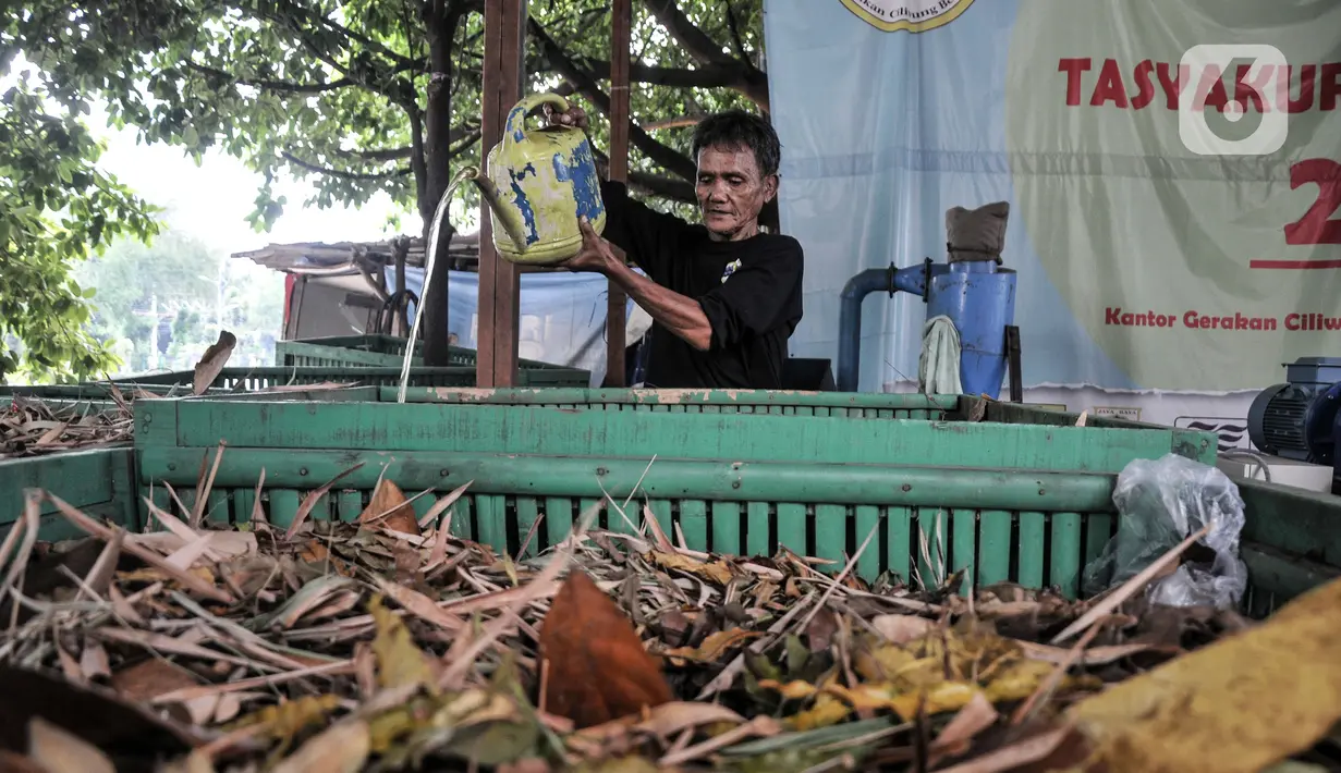 Petugas menuangkan cairan bioaktivator ke sampah organik yang telah dikumpulkan di Sekretariat Gerakan Ciliwung Bersih, Karet Bivak, Jakarta, Kamis (13/10/2022). Proses pembuatan bahan bakar nabati ini dimulai dengan mengolah sampah organik yang telah dipilah diberi cairan bioaktivator untuk menghilangkan bau. (merdeka.com/Iqbal S. Nugroho)