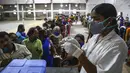 Seorang petugas kesehatan bersiap untuk memberikan vaksin Covaxin ketika ratusan orang berbaris untuk menerima dosis kedua di stadion kota di Hyderabad, India, Kamis (29/7/2021). (AP Photo/Mahesh Kumar A.)