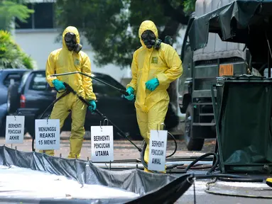 Tim Pasukan Gerak Cepat (PGC) melakukan sterilisasi sebuah mobil yang kedapatan positif terjangkit pandemi influenza H7N9 saat simulasi penanganan Episenter Pandemi Influenza di Puspiptek Tangerang Selatan, Rabu (20/9). (Liputan6.com/Helmi Afandi)