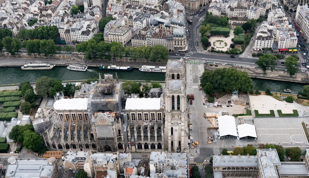 Katedral Notre Dame sedang menjalani restorasi setelah rusak parah akibat kebakaran hebat, Paris, Prancis, Minggu (14/7/2019). Proses ini diharapkan berlangsung hingga musim gugur. (Kenzo TRIBOUILLARD/AFP)