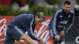 Lionel Messi (kanan) dan Lucas Biglia melakukan pemanasan saat sesi latihan jelang laga kualifikasi Piala Dunia 2018 di Ezeiza, Buenos Aires, (3/10/2017).  Argentina saat ini berada pada peringkat kelima klasemen. (AFP/Juan Mabromata)
