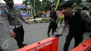 Petugas kepolisian bersiap memasang garis polisi di lokasi bom bunuh diri di Mapolresta Solo, Jawa Tengah, Selasa (5/7). Garis polisi itu dipasang mulai dari sisi barat jalan Adi Sucipto menuju sisi timur Jalan KS Tubun. (Liputan6.com/Boy Harjanto)