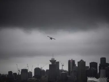 Sebuah pesawat amfibi lepas landas dari pelabuhan di bawah awan rendah di atas cakrawala pusat kota, di Vancouver, British Columbia, Kamis, (6/8/2020). (Darryl Dyck / The Canadian Press via AP)