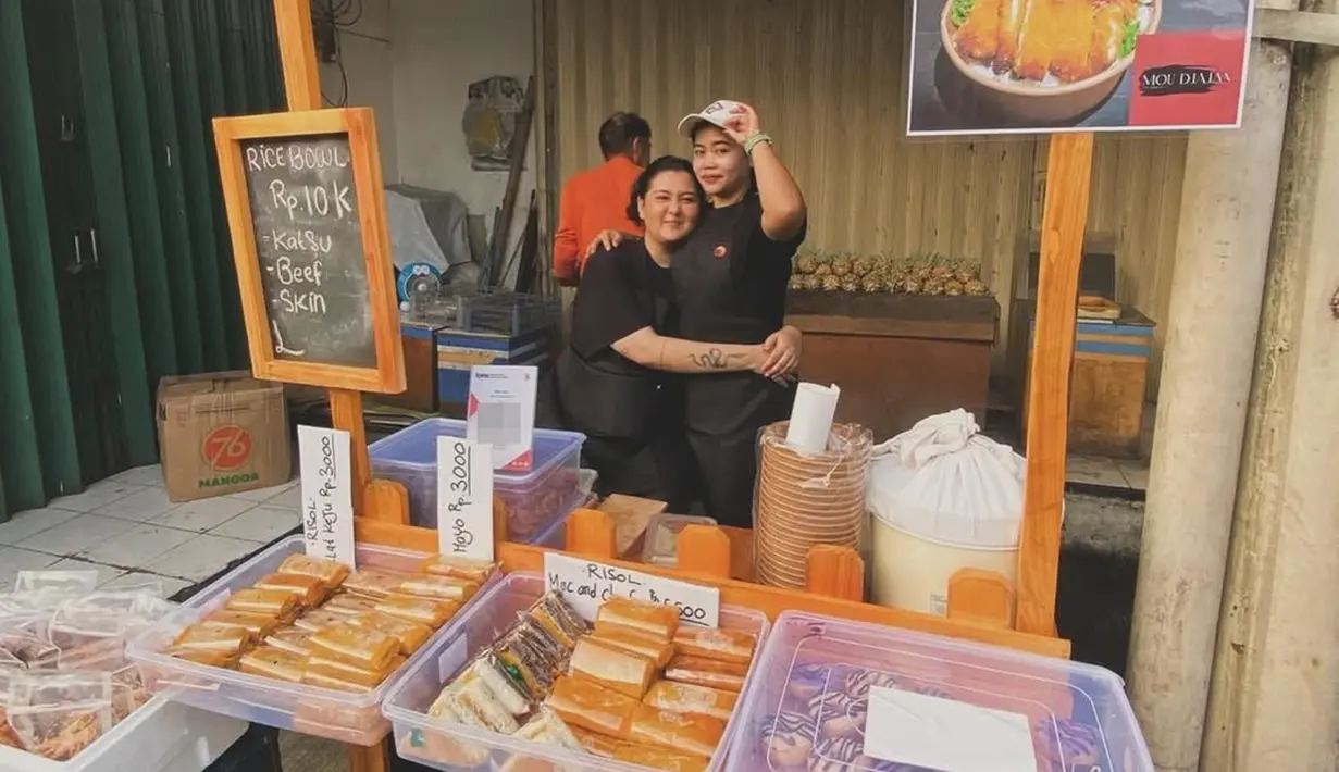 Tidak sendiri, bintang sinetron Ganteng-Ganteng Serigala ini berjualan bersama temannya. Talitha dan temannya kompak pakai baju warna hitam lengkap dengan celemek warna senada. Talitha tampil sederhana dengan mencepol rambutnya, sementara temannya mengenakan topi. Talitha dan temannya penuh semangat berjualan jajanan yang dinamai ‘Mou Jajan’ ini. (Liputan6.com/IG/@talithacurtis_)
