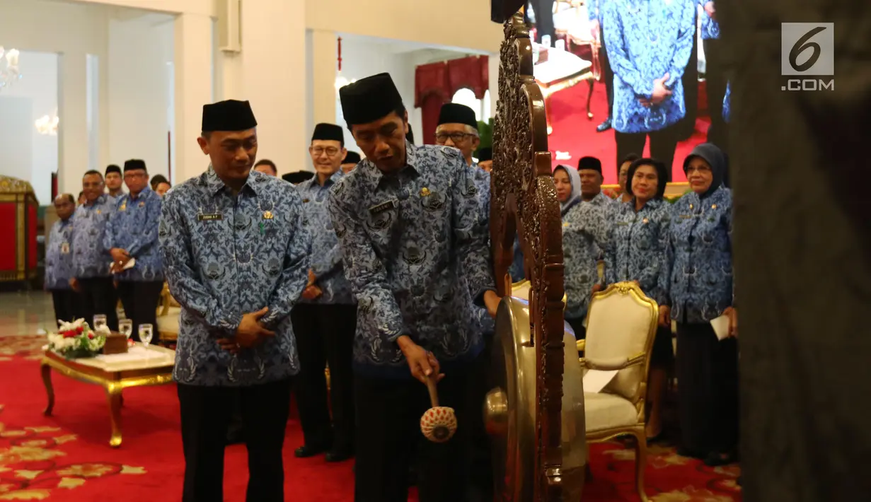 Presiden Joko Widodo (Jokowi) memukul gong saat membuka Rapat Kerja Nasional Korps Pegawai Republik Indonesia (KORPRI) 2019 di Istana Negara, Jakarta, Selasa (26/2) . (Liputan6.com/Angga Yuniar)
