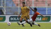 Pemain Borneo FC Samarinda, Nur Diansyah (kanan) berusaha menghentikan pergerakan pemain Bhayangkara Solo FC, TM Ichsan, dalam pertandingan Babak Penyisihan Piala Menpora 2021 di Stadion Kanjuruhan, Malang. Senin (22/3/2021). (Bola.com/Arief Bagus)