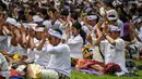 Sebelum melaksanakan upacara Melasti, umat Hindu terlebih dahulu melaksanakan persembahyangan yang dipimpin oleh seorang Romo dan Pinandita. (JUNI KRISWANTO/AFP)