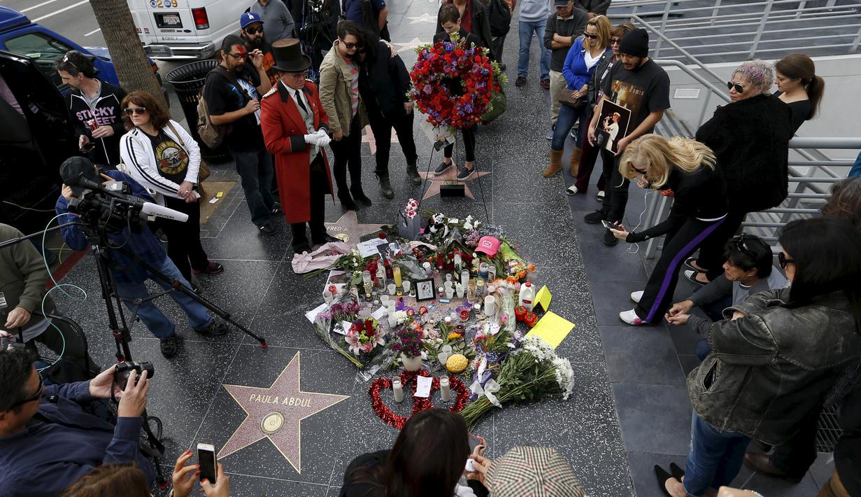 Penggemar berkumpul di dekat bintang atas nama penyanyi legendaris David Bowie di Hollywood Walk of Fame di Los Angeles, Senin (11/1). Bowie meninggal di usia 69 tahun dan baru saja merilis album ke-25 nya yaitu "Blackstar". (REUTERS/ Mario Anzuoni)