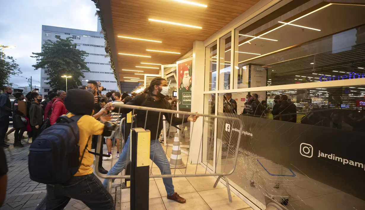 Demonstran mendobrak pintu masuk supermarket Carrefour selama protes terhadap pembunuhan pria kulit hitam Joao Alberto Silveira Freitas di Rio de Janeiro, Brasil (20/11/2020). Freitas meninggal setelah dipukuli oleh penjaga keamanan supermarket di kota Porto Alegre, Brasil selatan. (AP Photo/Bruna P