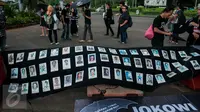 Sejumlah foto orang-orang yang hilang dipajang saat aksi Kamisan ke-482 di depan Istana Merdeka, Jakarta, Kamis (23/2). Mereka menuntut Presiden Jokowi untuk menuntaskan segala kasus pelanggaran HAM. (Liputan6.com/Gempur M Surya) 