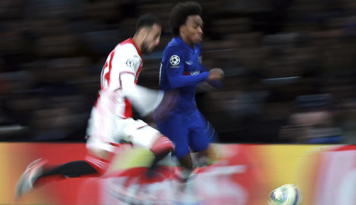 Gelandang Chelsea, Willian Chelsea (kanan) menggiring bola dari kejaran bek Ajax, Noussair Mazraoui  pada pertandingan lanjutan Grup H Liga Champions di Stamford Bridge, London (5/11/2019). Chelsea bermain imbang 4-4 atas Ajax. (AP Photo/Ian Walton)