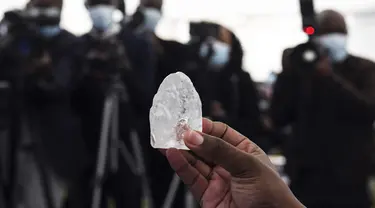 Seorang anggota kabinet Botswana memegang berlian permata di Gaborone, ibu kota Botswana, Rabu (16/6/2021). Batu itu - seberat 1.098 karat - diperlihatkan kepada Presiden Mokgweetsi Masisi, dua minggu setelah perusahaan berlian, Debswana, menggalinya. (Monirul Bhuiyan/AFP)
