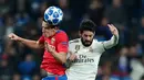 Pemain CSKA Moscow Kristijan Bistrovic melompat untuk berebut bola dengan bola gelandang Real Madrid, Isco pada laga terakhir Grup G Liga Champions di Santiago Bernabeu, Rabu (12/12). Real Madrid dipecundangi CSKA Moscow 0-3. (AP/Manu Fernandez)