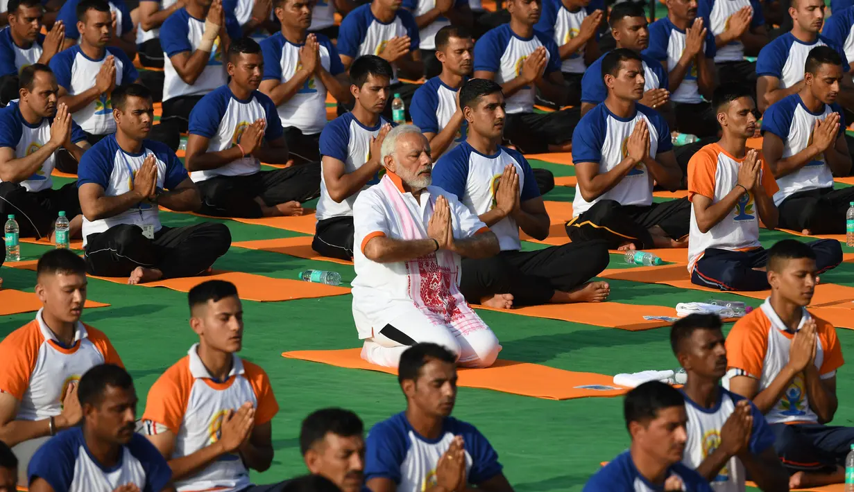 Perdana Menteri India, Narendra Modi berpartisipasi dalam sesi yoga massal pada Hari Yoga Internasional di Dehradun, Kamis (21/6). Modi melakukan gerakan peregangan, membungkuk, dan latihan pernapasan bersama praktisi yoga lainnya. (AFP/PRAKASH SINGH)