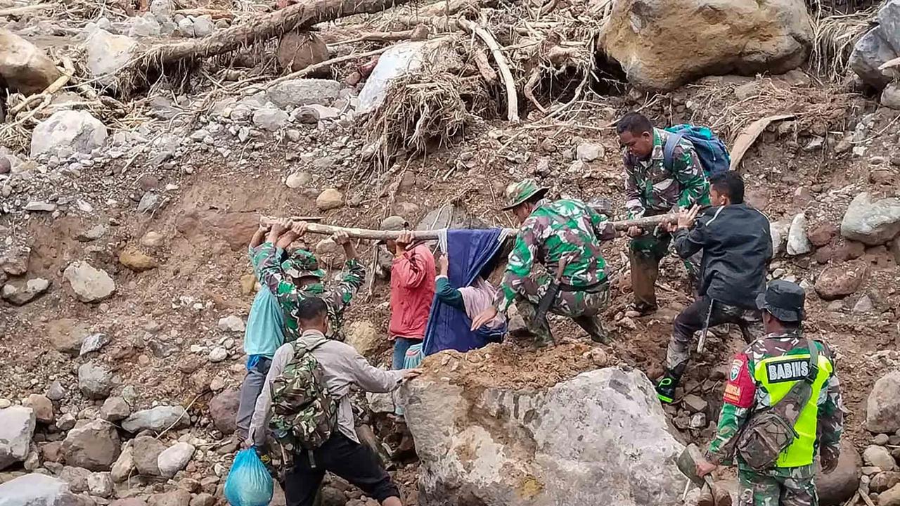 Anggota Koramil 05/Permata TNI AD mengevakuasi sepasang lansia dari wilayah terisolir menuju Puskesmas Buntul di Gucci Desa Burni Pase, Kecamatan Permata, Kabupaten Bener Meriah, Kamis (11/12/2025).
