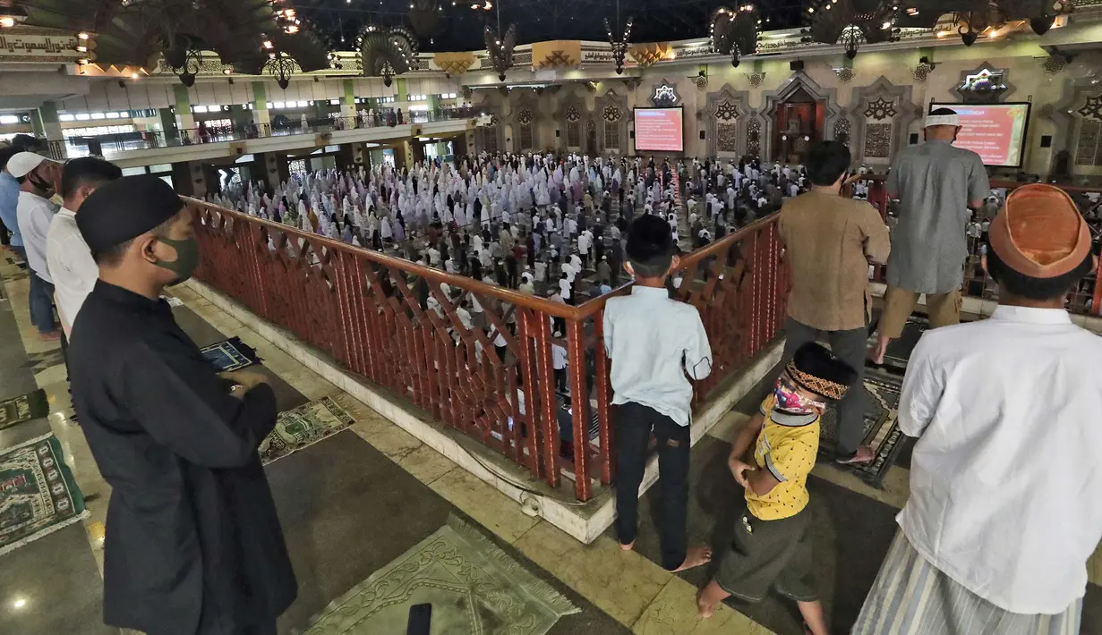 Umat Muslim berdoa terpisah dengan mengenakan masker selama salat Idul Adha di sebuah masjid di Jakarta, Indonesia, 31 Juli 2020. Idul Adha, atau Pesta Kurban, ditandai dengan mengorbankan hewan untuk memperingati iman Nabi Ibrahim karena bersedia mengorbankan putranya. (AP Photo/Tatan Syuflana)