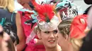 Wanita memakai hiasan kepala dari berbagai macam bulu saat menghadiri balap kuda Melbourne di arena pacuan kuda Flemington Racecourse, Australia (1/11). Flemington merupakan arena pacuan kuda sekaligus tempat hiburan kelas dunia. (AFP/Paul Crock)