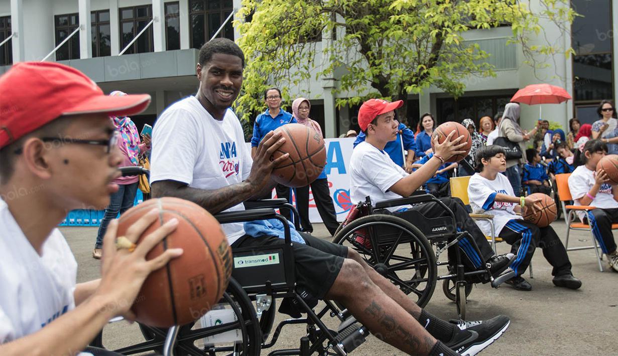 Pebasket NBA asal klub Charlotte Hornets, Marvin Williams, mengajarkan dribbling kepada para penyandang disabilitas. (Bola.com/Vitalis Yogi Trisna)