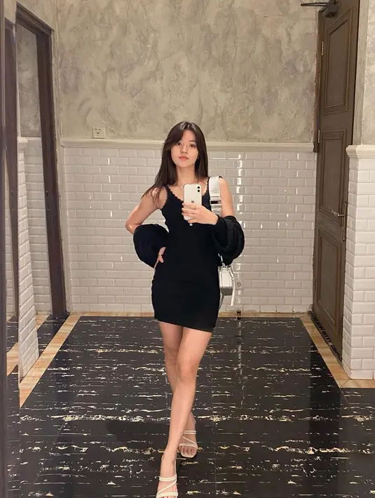 Padu padan mini black dress dan heels putih ala Vonzy cocok digunakan untuk acara formal. (sumber : Instagram @vonnyfelicia)