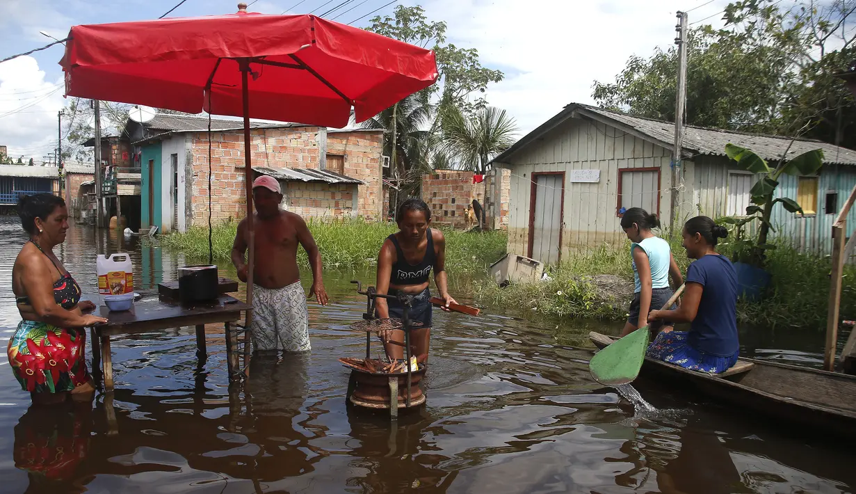 <p>Warga memasak di jalan yang dibanjiri oleh naiknya sungai Negro di Iranduba, negara bagian Amazonas, Brasil, Senin (23/5/2022). Wilayah Amazon sedang dilanda banjir dengan 35 kotamadya yang menghadapi salah satu banjir terburuk mereka dalam beberapa tahun dan permukaan air diperkirakan akan meningkat selama beberapa bulan mendatang. (AP Photo/Edmar Barros)</p>