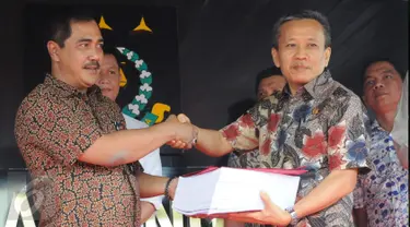 Dirtipidum Bareskrim Polri Brigjen Agus Andrianto (kiri) menyerahkan berkas perkara tahap 1 kepada Ketua Jaksa Peneliti Berkas Perkara Ahok, Ali Mukartono di Kejaksaan Agung, Jakarta, Jumat (25/11). (Liputan6.com/Helmi Afandi)