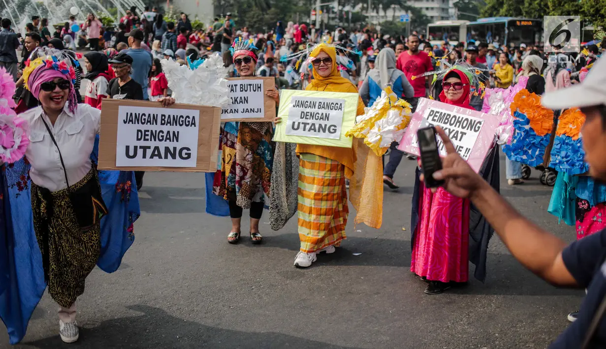 Sejumlah wanita yang tergabung dalam Emak-Emak Istana Cantik menggelar aksi saat car free day (CFD) di Bundaran HI, Jakarta, Minggu (4/8/2019). Dalam aksinya, mereka mengkritik kebijakan pemerintah soal ekonomi. (Liputan6.com/Faizal Fanani)