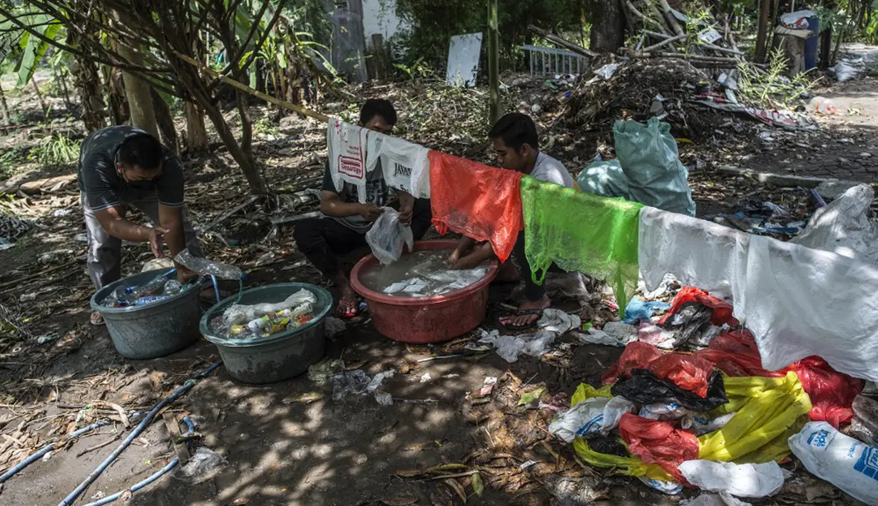 Aktivis Ecological Observation and Wetland Conservation (Ecoton) mencuci sampah plastik untuk membuat instalasi di Gresik, Jawa Timur, 17 September 2021. Instalasi tersebut di antaranya terbuat dari 4.444 botol. (JUNI KRISWANTO/AFP)
