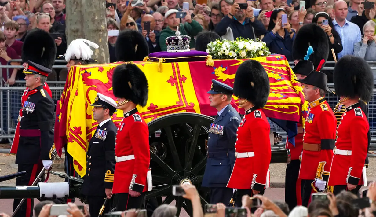 Band Coldstream Guards tampil saat prosesi Ratu Elizabeth II di London, Inggris, 14 September 2022. Warga berada di kanan-kiri jalan untuk menyaksikan keberangkatan peti jenazah Ratu Elizabeth II dari Istana Buckingham yang telah menjadi rumahnya sebagai ratu selama 70 tahun terakhir. (Nathan Denette/The Canadian Press via AP)