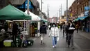 Pembeli berjalan melewati kios di pasar di Walthamstow, London timur pada 13 Februari 2022. Angka inflasi Inggris tembus 5,4 persen pada Desember lalu. Inflasi itu juga menjadi yang tertinggi dalam 30 tahun terakhir. (Tolga Akmen / AFP)