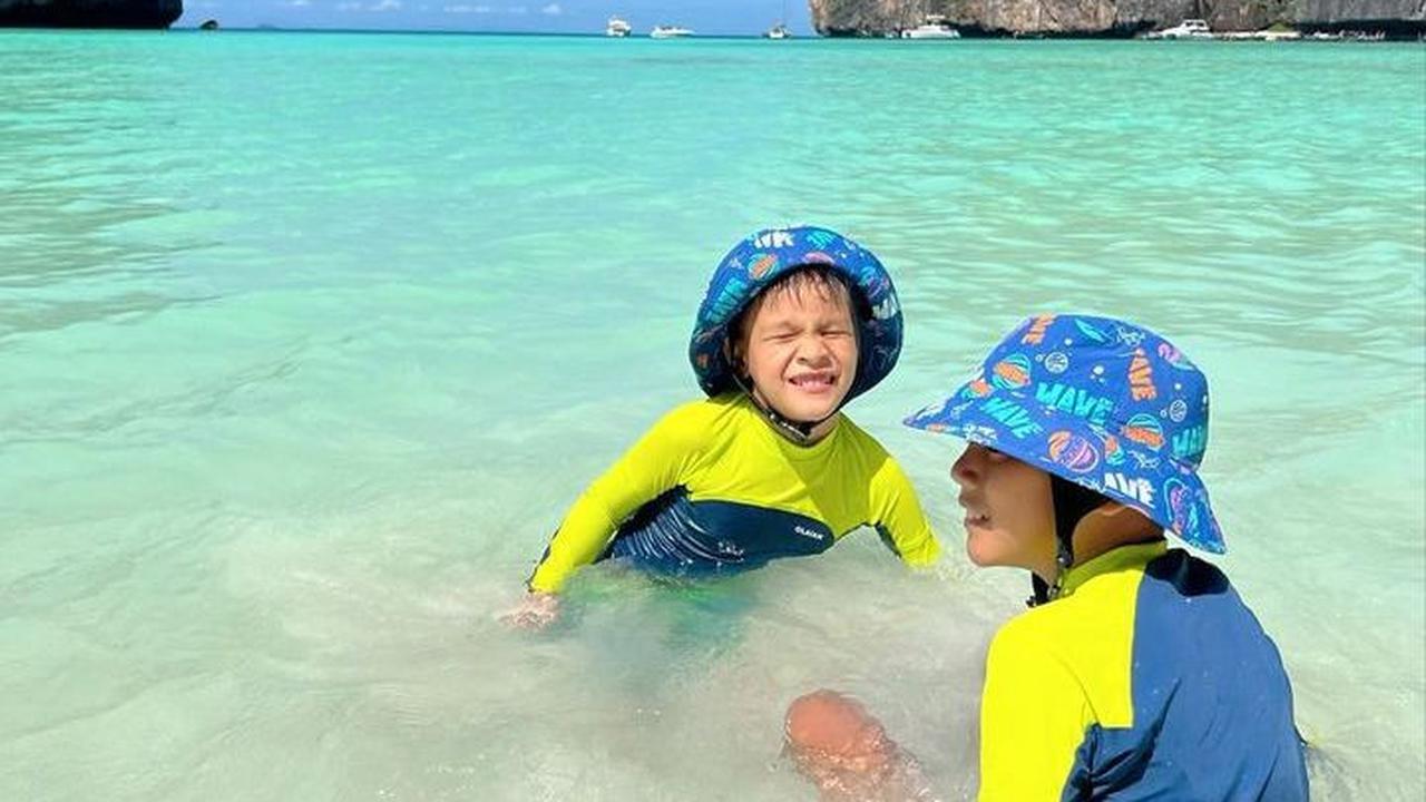 Potret Kai bersama sang kakak, Arjuna saat sedang main di pantai. Tampak pemandangan pantai yang begitu indah. Kai dan Arjuna tampak asyik berenang.<br>