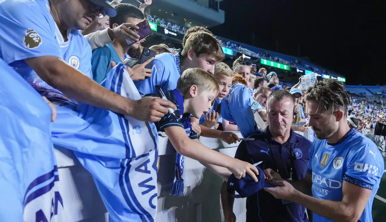 Pemain Manchester City, Jack Grealish, memberikan tanda tangan kepada fans setelah laga melawan Glasgow Celtic pada laga uji coba di Stadion Kenan Memorial, Rabu (24/7/2024). (AFP/Grant Halverson)