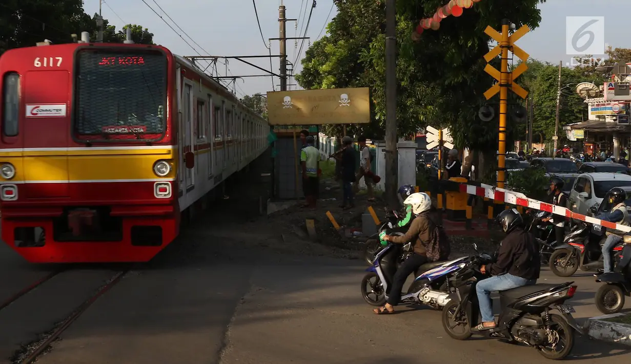Kereta api melintas di kawasan Lenteng Agung, Jakarta, Kamis (14/3). Untuk mengurai kemacetan, Pemprov DKI Jakarta akan membangun jalan layang (fly over) berbentuk tapal kuda di perlintasan tersebut. (Liputan6.com/Immanuel Antonius)