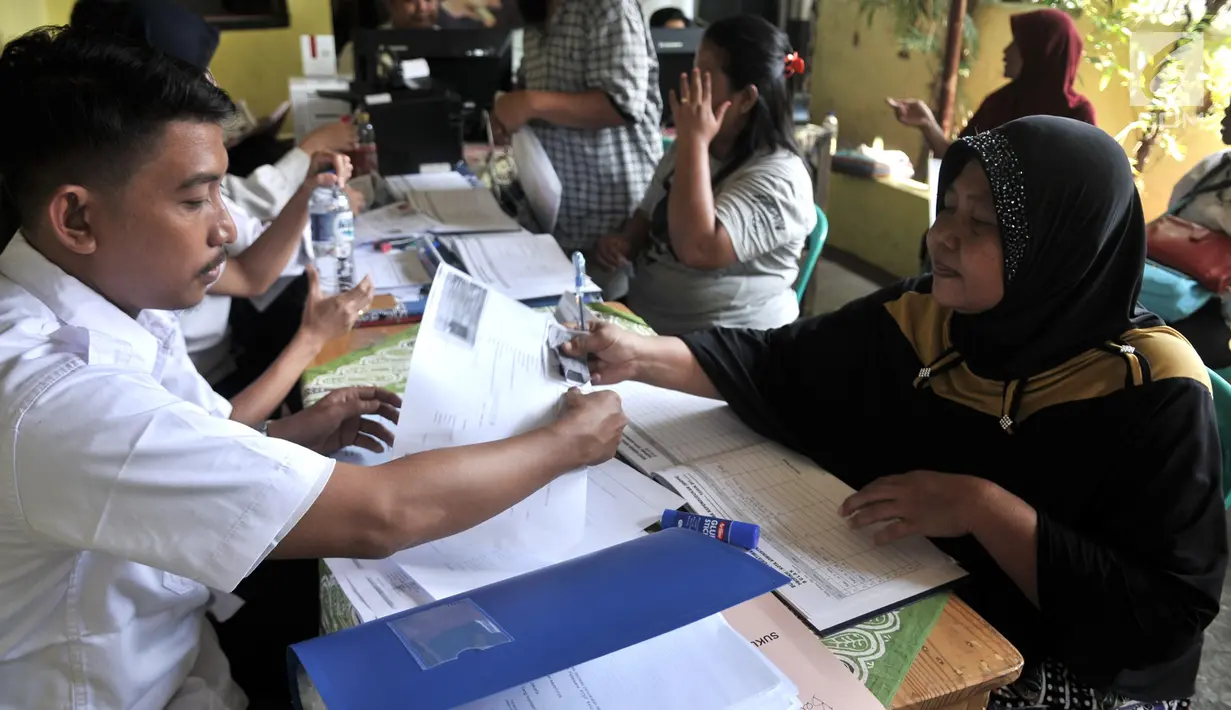 Petugas Dukcapil Jakarta Pusat melayani warga yang mengikuti Bina Kependudukan (Biduk) di Pal Putih, Kramat, Senen, Jakarta, Rabu (10/7/2019). Biduk ini digelar dalam rangka mendata warga pendatang pasca-Lebaran 2019. (merdeka.com/Iqbal Nugroho)