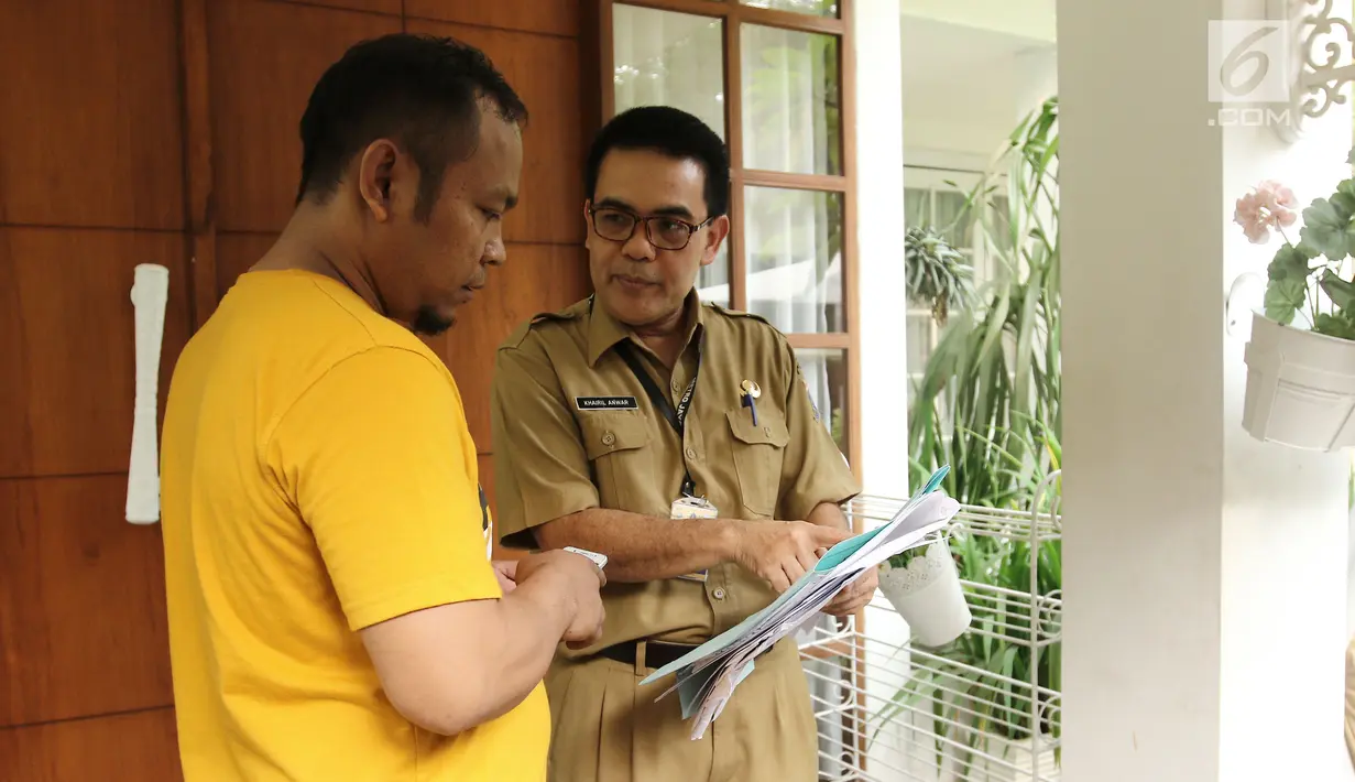 Petugas Badan Pajak dan Retribusi Jakarta memberikan informasi ke asisten rumah tangga Raffi Ahmad terkait dengan pajak kendaraan bermotor di kawasan Pondok Labu, Jakarta, Selasa (22/8). (Liputan6.com/Herman Zakharia)