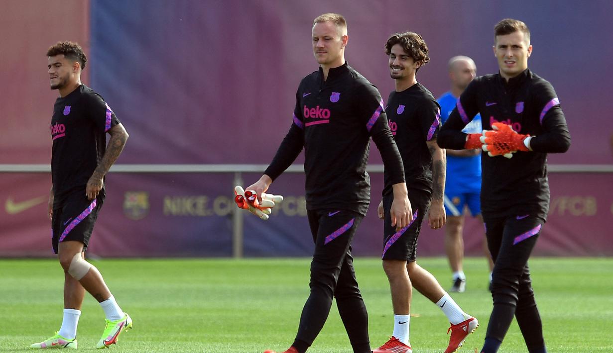 Kiper Barcelona Marc-Andre ter Stegen (kedua kiri) dan Inaki Pena menghadiri sesi latihan di Joan Gamper di Sant Joan Despi, Senin (13/9/2021). Barcelona akan berhadapan dengan Bayern Munchen pada matchday pertama grup E Liga Champions 2021/2022, Rabu dini hari 15 September. (Josep LAGO/AFP)