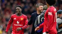 Pelatih interim Manchester United, Michael Carrick, meninggalkan lapangan bersama Kobbie Mainoo dari Manchester United di akhir pertandingan Liga Inggris antara Manchester United dan Liverpool di Manchester, Inggris, Minggu, 3 Mei 2026. (Foto AP/Dave Thompson)