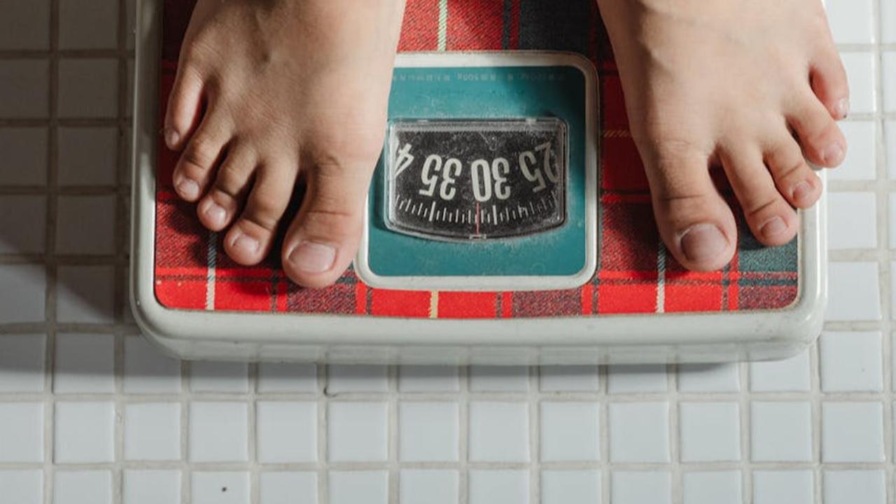 Ilustrasi Orang sedang Mengecek Berat Badan yang Bertambah