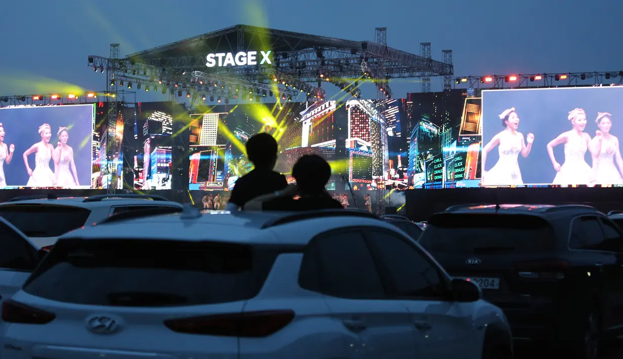 Orang-orang menyaksikan konser drive-in Stage X dari dalam mobil di sebuah tempat parkir di Goyang, Korea Selatan, 23 Mei 2020. Tujuan konser ini untuk memberikan hiburan bagi warga Korea Selatan yang mendambakan acara-acara musik yang ditangguhkan selama pandemi Covid-19. (AP Photo/Ahn Young-joo)