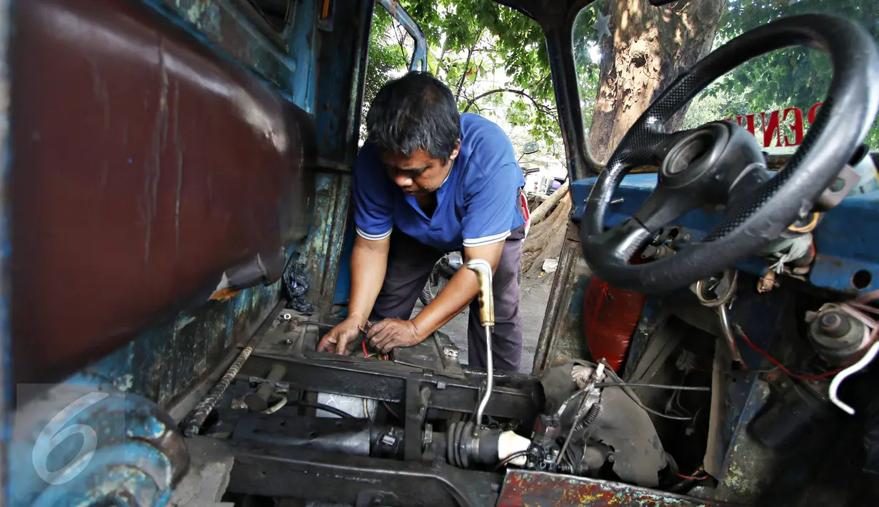 Sopir mengecek kondisi bemo di kawasan Bendungan Hilir, Jakarta, Kamis (22/10/2015). Maraknya perkembangan transportasi online di Ibu Kota membuat keberadaan angkutan bemo kian terpinggirkan akibat kalah bersaing. (Liputan6.com/Immanuel Antonius)