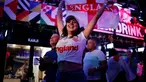 Pendukung Inggris merayakan kemenangan usai peluit akhir dibunyikan  pada pertandingan semifinal EURO 2020 antara Inggris dan Denmark, di Boxpark Croydon di London selatan (8/7/2021). Inggris menang atas Denmark dengan skor 2-1. (AFP/Tolga Akmen)