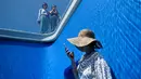 Orang-orang mengunjungi karya seni Swimming Pool dalam sebuah pameran di Museum CAFA, Beijing, 23 Juli 2019. Bagian atas karya seni unik itu berlapis kaca transparan yang dilapisi air sedalam 10 cm, sedangkan bagian bawahnya merupakan ruang kosong dengan dinding berwarna biru muda. (WANG Zhao/AFP)